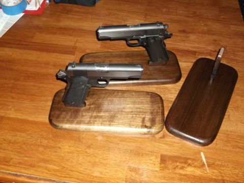 1995 Mercury Grand Marquis - Two handguns are displayed on wooden stands on a wooden table surface.