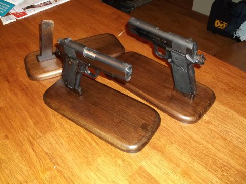 1995 Mercury Grand Marquis - Two handguns are displayed on wooden stands on a wooden table surface.