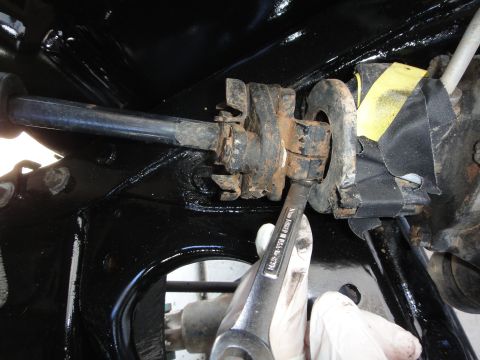1988 Ford Bronco - Mechanic works on a vehicle's steering linkage, likely during a repair or maintenance procedure.
