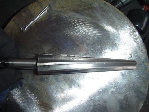 1993 Ford Bronco - A reamer tool and a cotter pin are shown resting on a textured metal surface.