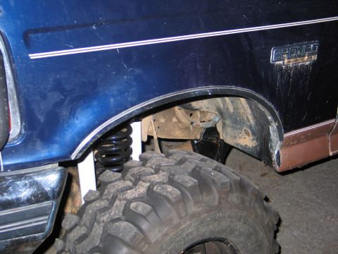 1995 Ford Bronco - Close-up of a 1995 Ford Bronco's fender, tire, and suspension system.