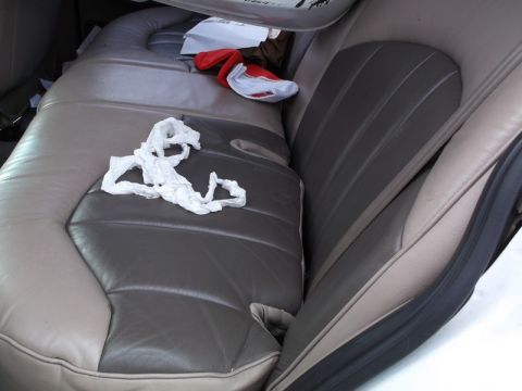 1999 Mercury Grand Marquis - The interior of a car shows a messy back seat with trash and other items strewn about.
