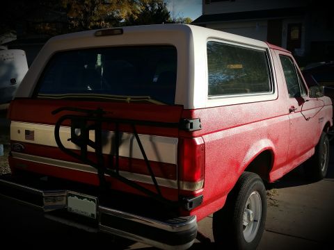 1988 Ford Bronco - This 1988 Ford Bronco is shown from the rear, a two-tone red and white paint scheme and a spare tire carrier.