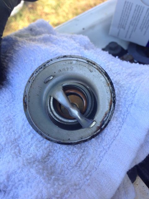 1979 Ford Bronco - A close-up view of a car thermostat, showing the "54MM" marking.
