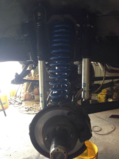 1979 Ford Bronco - Close-up view of the vehicle's suspension system, showing blue coil springs and silver shock absorbers.
