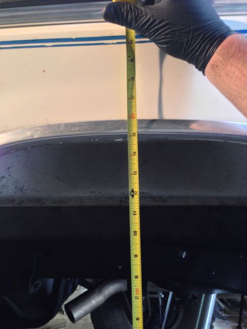 1979 Ford Bronco - A tape measure is used to check the height of a vehicle's wheel well.