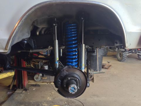 1979 Ford Bronco - Close-up of the front suspension system, bright blue coil springs and silver Bilstein shock absorbers, likely on a 1979 Ford Bronco.