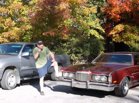 1979 Ford Ranchero - Man poses with a silver pickup and a maroon 1977 Mercury Cougar XR-7 in front of autumn trees.