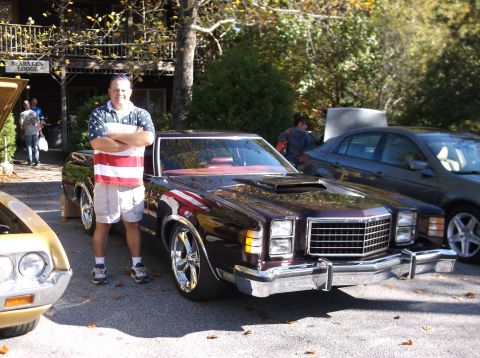1979 Ford Ranchero - A man poses with a dark red 1979 Ford Ranchero, custom chrome wheels and a prominent hood scoop.