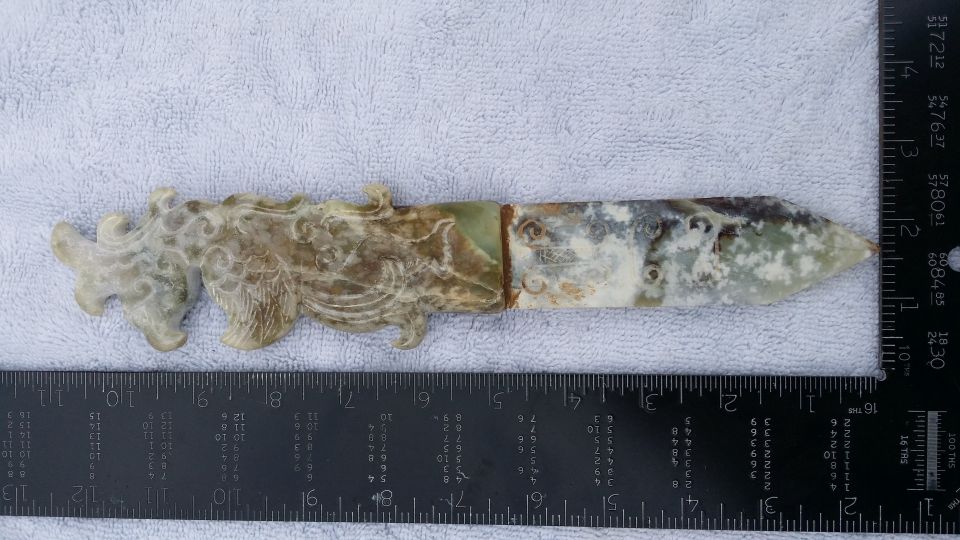 Ornate jade dagger with dragon motif, measured against a ruler