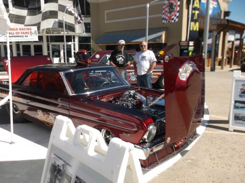 1979 Ford Ranchero - A customized classic car with its hood open is displayed at an outdoor event, with two men standing beside it.