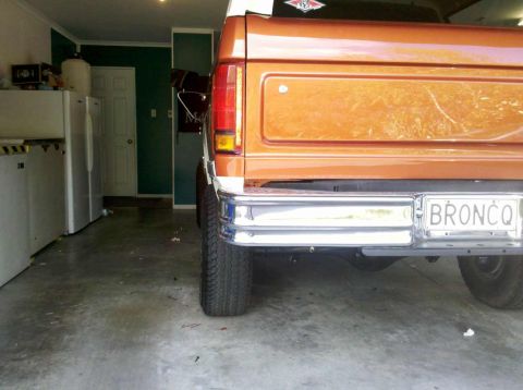 1982 Ford Bronco - The rear of a Ford Bronco is visible, parked inside a garage with appliances in the background.