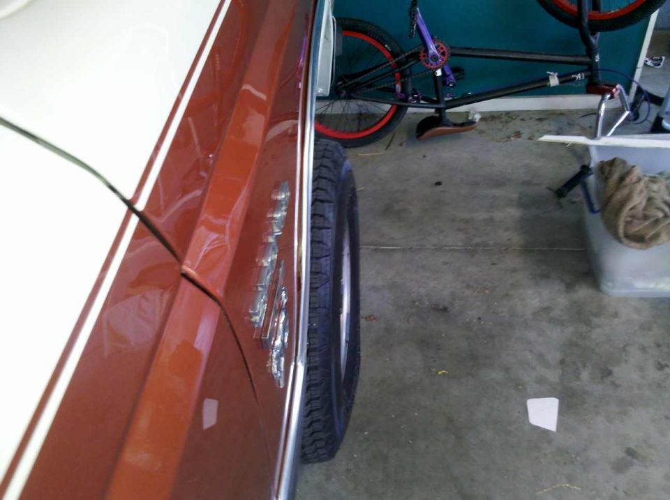 Brown and white Ford Bronco side view, showing fender and tire