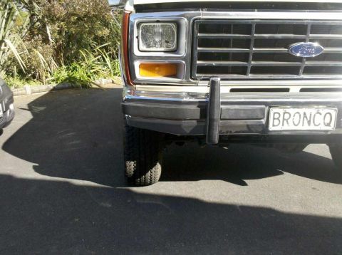 1982 Ford Bronco - The front grille and headlights of a Ford Bronco are visible, with a license plate reading BRONCO.