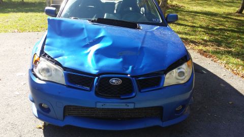 2007 Subaru Impreza - Front view of a blue Subaru Impreza with significant front-end damage, likely from an accident.