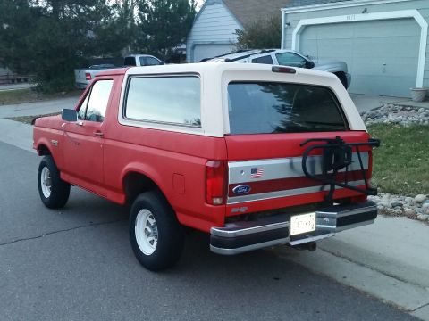 1988 Ford Bronco - This 1988 Ford Bronco is shown in a rear three-quarter view, a red body and a white removable top.
