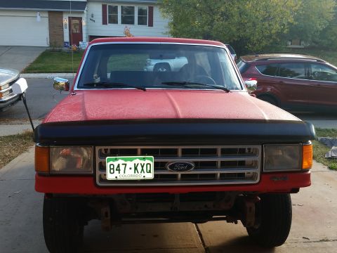 1988 Ford Bronco - Front view of a red 1988 Ford Bronco, showing its grille and Colorado license plate.