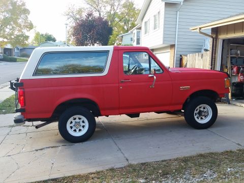 1988 Ford Bronco - This Ford Bronco is parked in front of a house and garage.