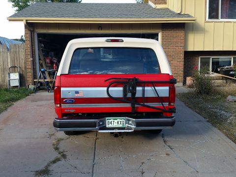 1988 Ford Bronco - This 1988 Ford Bronco features a two-tone red and white paint scheme and a rear-mounted spare tire carrier.