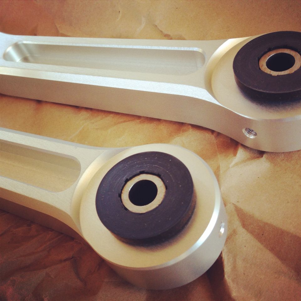 Two silver aluminum Metco Watts links with black rubber bushings on brown paper