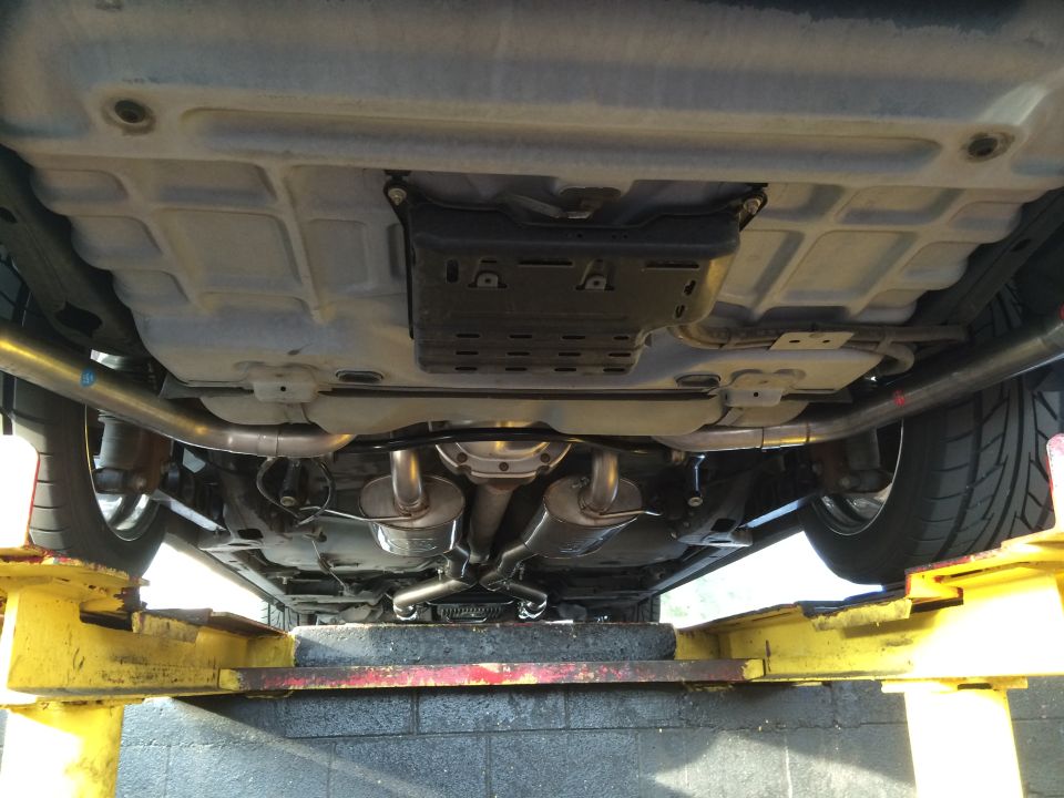 Underbody view of a car with dual exhaust pipes and mufflers