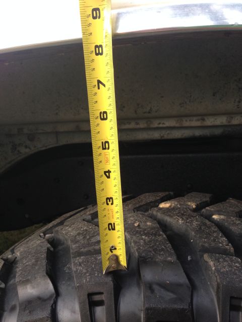 1979 Ford Bronco - A measuring tape is used to show the gap between a tire and the vehicle's fender.