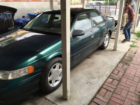 1993 Ford Taurus - This 1993 Ford Taurus is parked under a carport, partially obscured by a support beam.