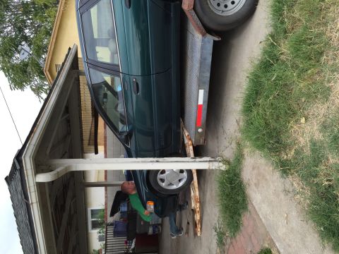 1993 Ford Taurus - A green 1993 Ford Taurus is loaded onto a trailer under a carport.