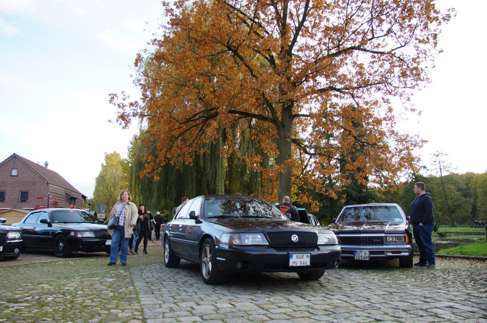 Black 2003 Mercury Marauder parked on cobblestones, front-right view, with autumn trees in background