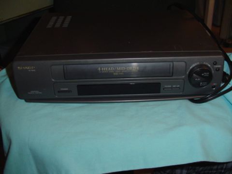 1999 Ford Taurus - A Sharp VCR is shown from the front, resting on a light blue cloth.