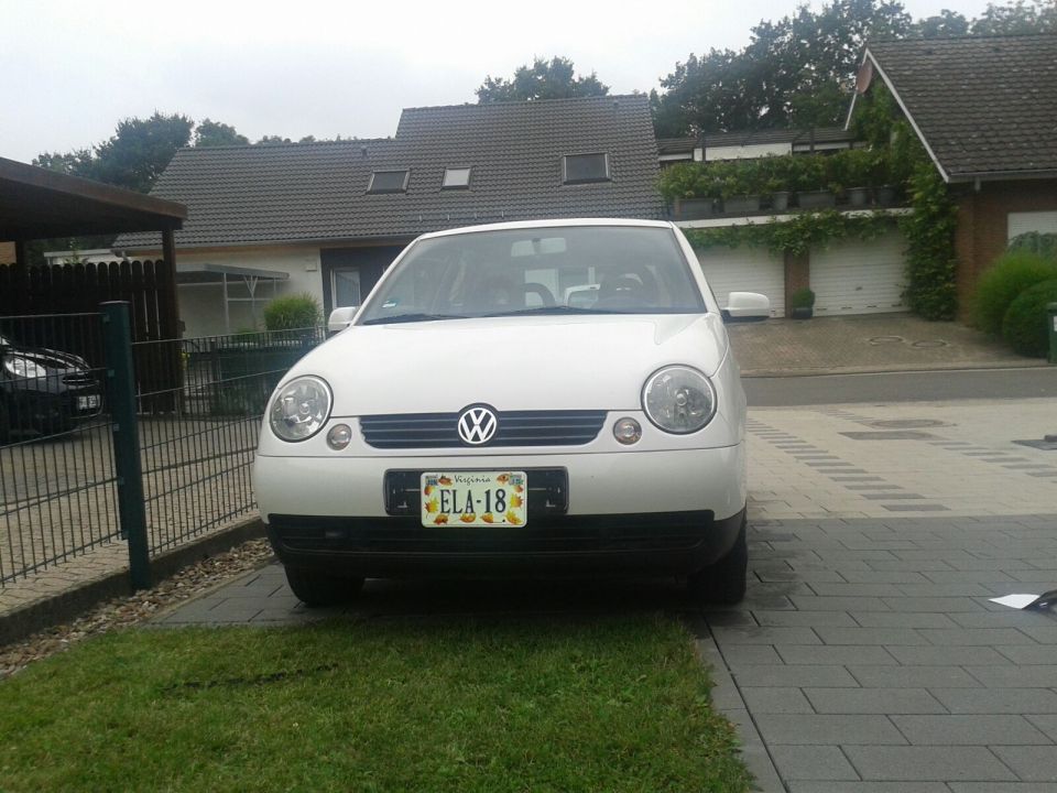 White Volkswagen Lupo parked in driveway, front view. License plate ELA-18