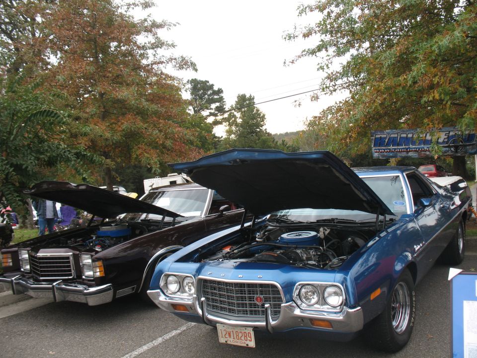 1972 Ford Ranchero and a dark sedan, both with hoods open, parked outdoors