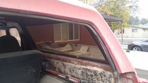 1981 Ford Bronco - Interior view of a red SUV, possibly from the early 1980s, with a boat visible through the rear window.