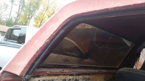 1981 Ford Bronco - Interior view of a red vehicle, showing a cracked window and surrounding trim.