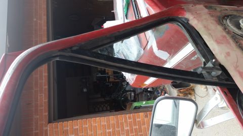 1981 Ford Bronco - Close-up of the interior frame and weatherstripping on a red vehicle, with a Supermotors.net logo in the corner.