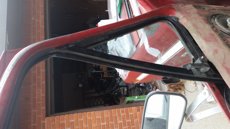 Red vehicle interior frame with weatherstripping and a side mirror. Supermotors.net logo visible