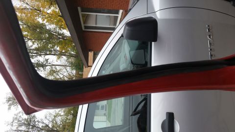 1981 Ford Bronco - Close-up of a silver truck's door frame and side mirror, showing interior trim.