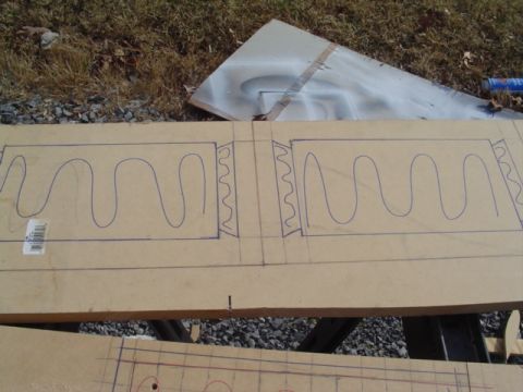 1999 Ford Taurus - Sheet of MDF laid across sawhorses outdoors with mirrored serpentine wave patterns drawn in blue marker, laid out as amplifier rack panels…