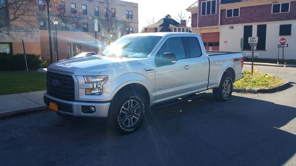 Silver 2015 Ford F-150 SuperCrew pickup truck parked on asphalt