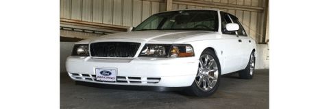 2000 Mercury Grand Marquis - A white sedan is parked inside a garage with a metal wall in the background.