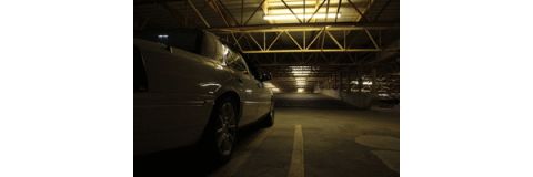 2000 Mercury Grand Marquis - A white sedan is parked in a garage, with the camera angled towards the rear of the vehicle.