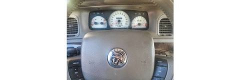 2000 Mercury Grand Marquis - The interior of a 2000 Mercury Grand Marquis, its dashboard gauges and steering wheel emblem.