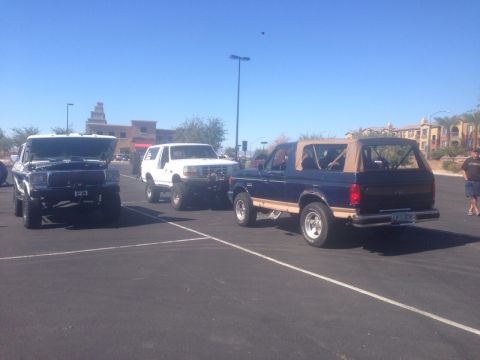 1978 Ford Bronco - Three Ford Broncos are parked in a lot on a sunny day.