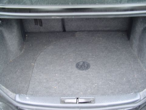 1999 Ford Taurus - The interior of a car's trunk is shown, gray carpeting and a visible SuperMotors watermark.