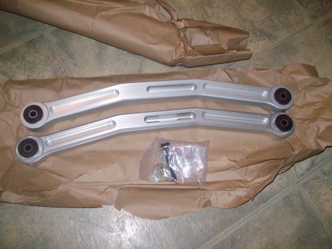 2004 Ford Crown Victoria - Aftermarket control arms and hardware are shown, packaged on brown paper.