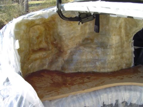 1999 Ford Taurus - The interior of a car trunk is lined with fiberglass insulation, suggesting a repair or modification.