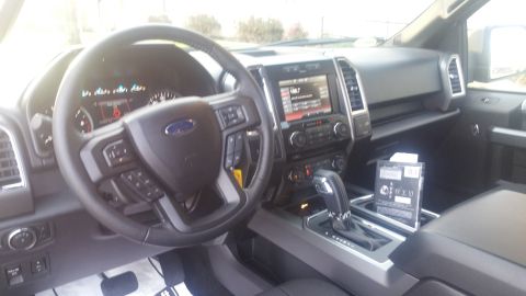 2015 Ford F-150 - The interior of a 2015 Ford F-150 features a modern dashboard with a large infotainment screen and a multi-function steering wheel.