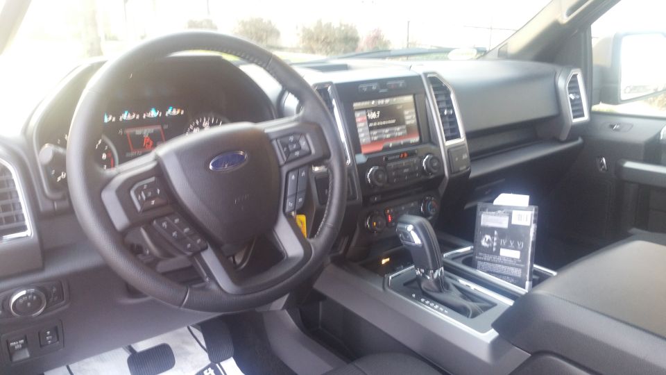 Interior of a 2015 Ford F-150 showing the dashboard, steering wheel, and center console