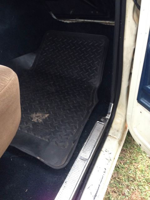 1979 Ford Bronco - Close-up view of the interior floor and door sill of a vehicle.