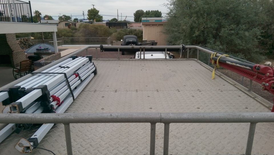 roof rack loaded with tent poles and a red hi-lift jack